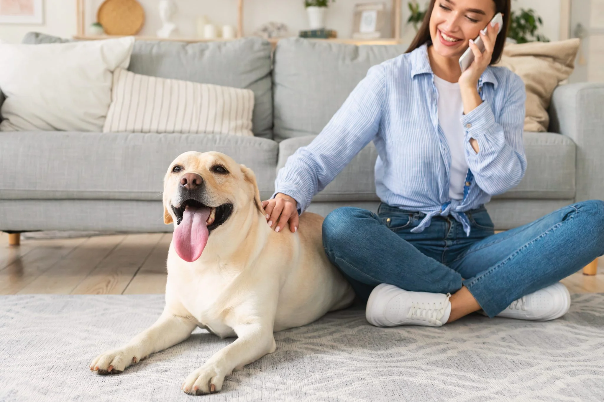 Portrait of young woman with her dog using mobile
