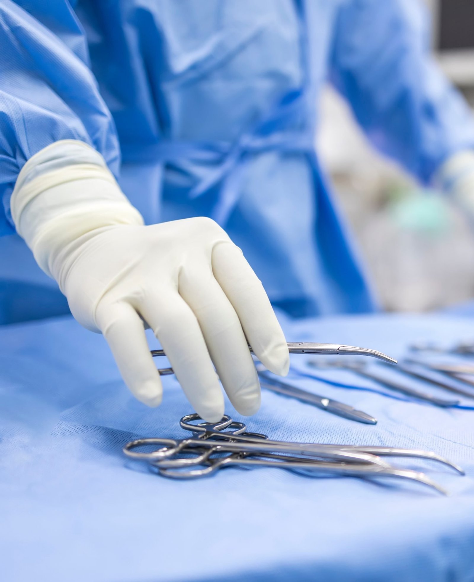 O mana de medic veterinar ce se pregateste de operatie